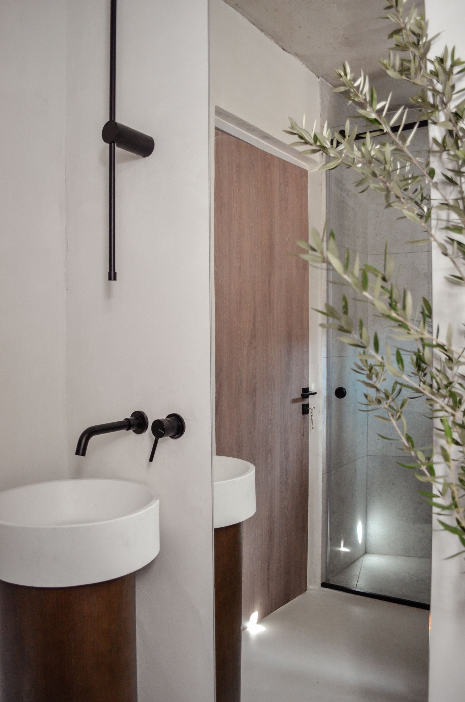 Bathroom with a vessel basin, dark fixtures and a tree beside the window — Amoni