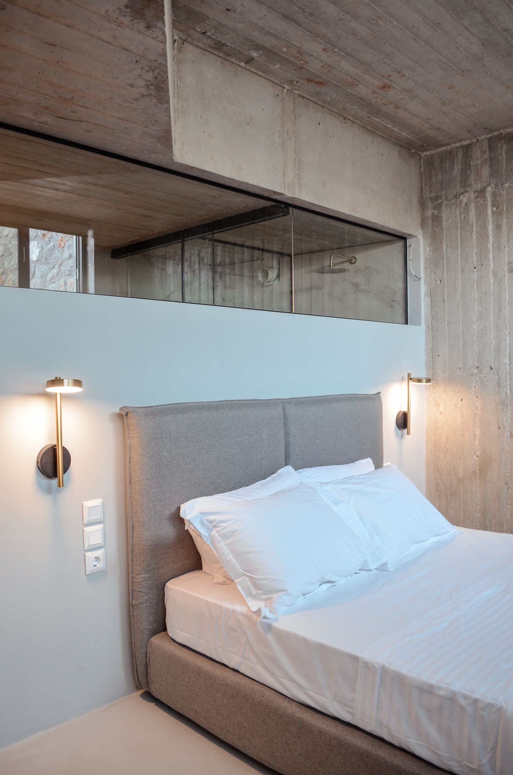 Bedroom with white bedding, a broad mirror and bedside pendant lighting — Amoni