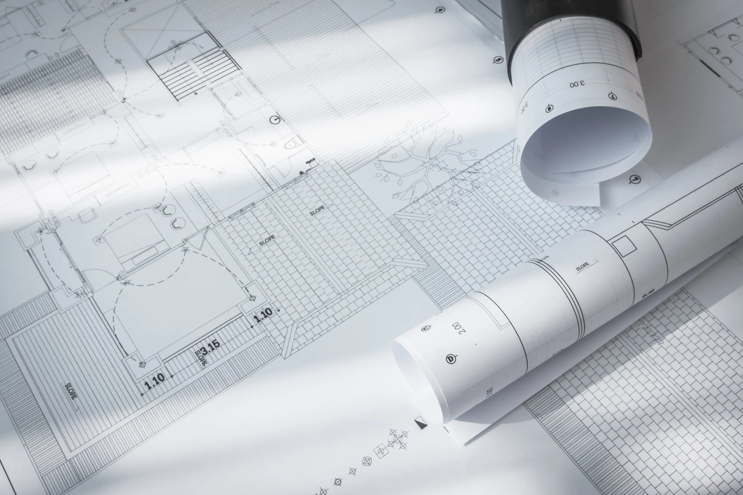 Rolled architectural drawings on top of a floor plan