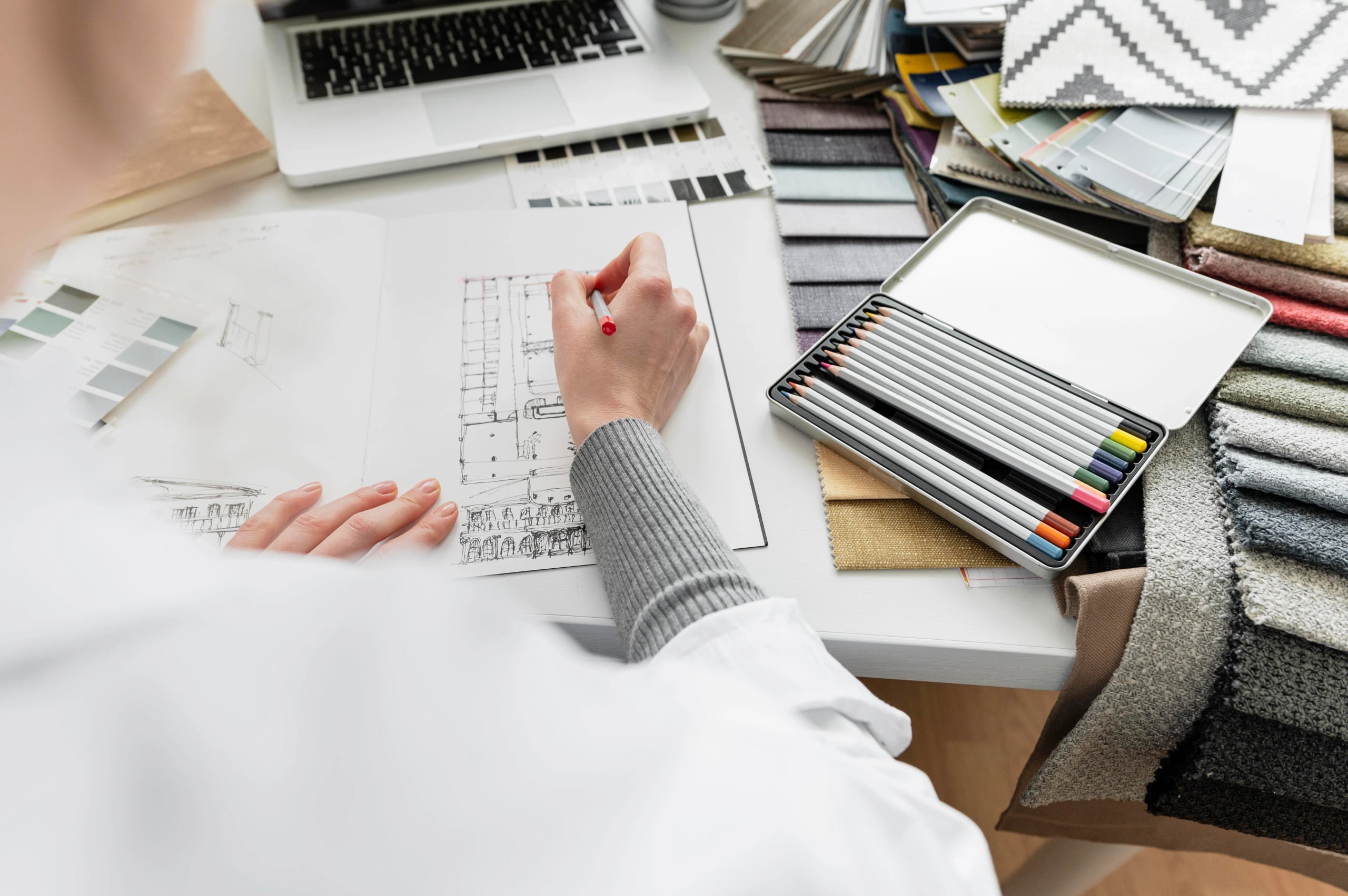 Designer reviewing sketches and material samples at a desk